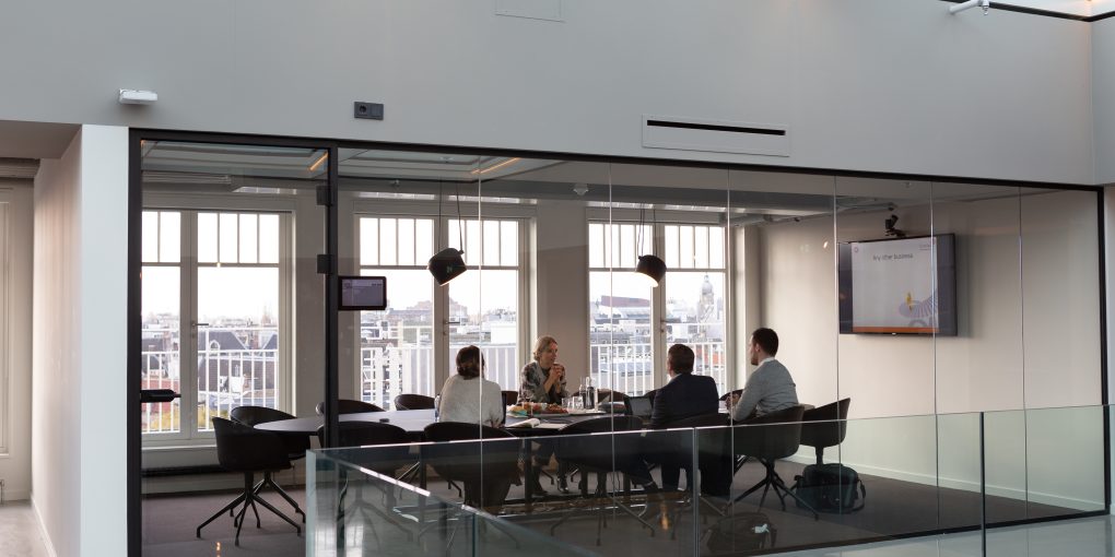 A group of entrepreneurs similar to Elijah Norton meet in a conference room